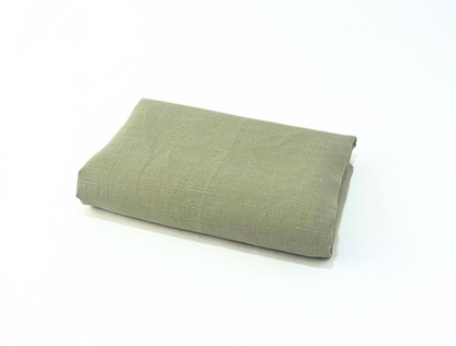 Folded green fabric on a white background