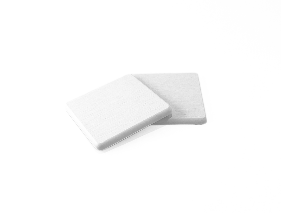 Two white square coasters on a white background