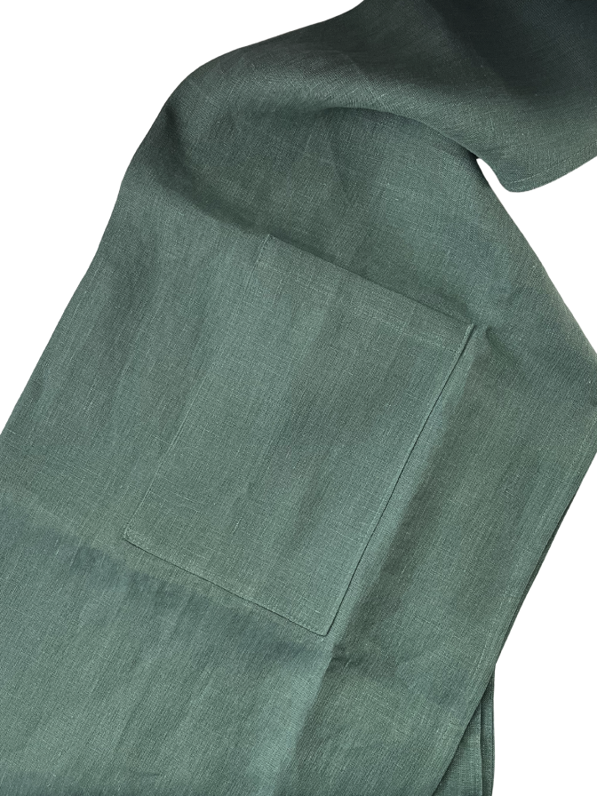 Close-up of a olive green apron with a pocket detail on a white background