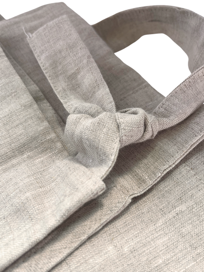 Close-up of a gray apron with a handle and strap.