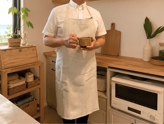 Person wearing an apron holding a bowl in a kitchen setting