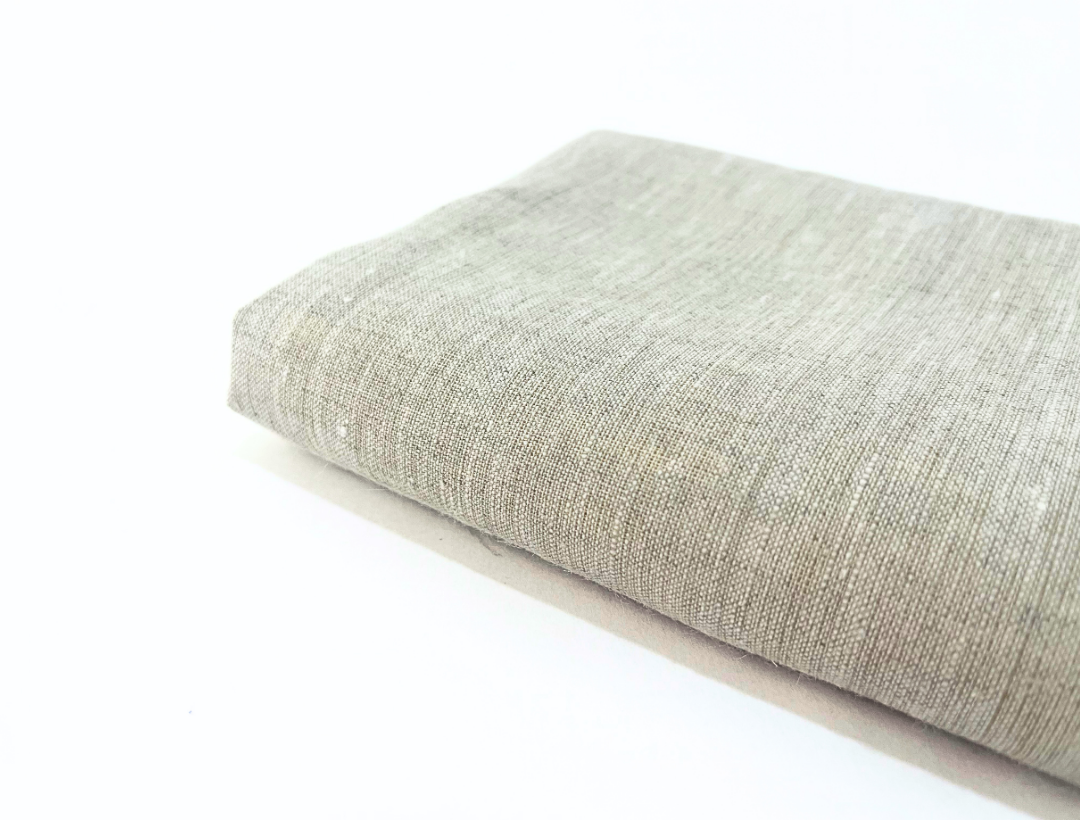 Textured greige linen towel on a white background